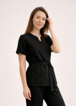 NOWA! TUNIKA MEDYCZNA – KOPERTOWA Nasza tunika przeszła prawdziwą metamorfozę – uwzględniliśmy wszystkie opinie naszych klientek, aby stworzyć model jeszcze lepszy i bardziej komfortowy w codziennej pracy. Nowa tunika nie rozchodzi się na biuście, dzięki czemu zapewnia pełną swobodę ruchów i komfort podczas pracy z pacjentem. Głębsze założenie na biuście sprawia, że nie ma potrzeby zakładania dodatkowego trykotu, a rezygnacja z mało estetycznych zatrzasków gwarantuje perfekcyjne ułożenie materiału. Wiązanie w talii pozwala dopasować tunikę do każdej sylwetki, podkreślając kobiece kształty i jednocześnie dbając o wygodę przez cały dzień. Pionowe cięcia wysmuklają sylwetkę, nadając całości eleganckiego charakteru. Dodatkowym atutem są trzy praktyczne kieszenie, w tym jedna zaprojektowana specjalnie na telefon. Poznaj i pokochaj naszą nową tunikę – stworzoną z myślą o Tobie!