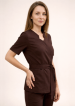 NOWA! TUNIKA MEDYCZNA – KOPERTOWA Nasza tunika przeszła prawdziwą metamorfozę – uwzględniliśmy wszystkie opinie naszych klientek, aby stworzyć model jeszcze lepszy i bardziej komfortowy w codziennej pracy. Nowa tunika nie rozchodzi się na biuście, dzięki czemu zapewnia pełną swobodę ruchów i komfort podczas pracy z pacjentem. Głębsze założenie na biuście sprawia, że nie ma potrzeby zakładania dodatkowego trykotu, a rezygnacja z mało estetycznych zatrzasków gwarantuje perfekcyjne ułożenie materiału. Wiązanie w talii pozwala dopasować tunikę do każdej sylwetki, podkreślając kobiece kształty i jednocześnie dbając o wygodę przez cały dzień. Pionowe cięcia wysmuklają sylwetkę, nadając całości eleganckiego charakteru. Dodatkowym atutem są trzy praktyczne kieszenie, w tym jedna zaprojektowana specjalnie na telefon. Poznaj i pokochaj naszą nową tunikę – stworzoną z myślą o Tobie!